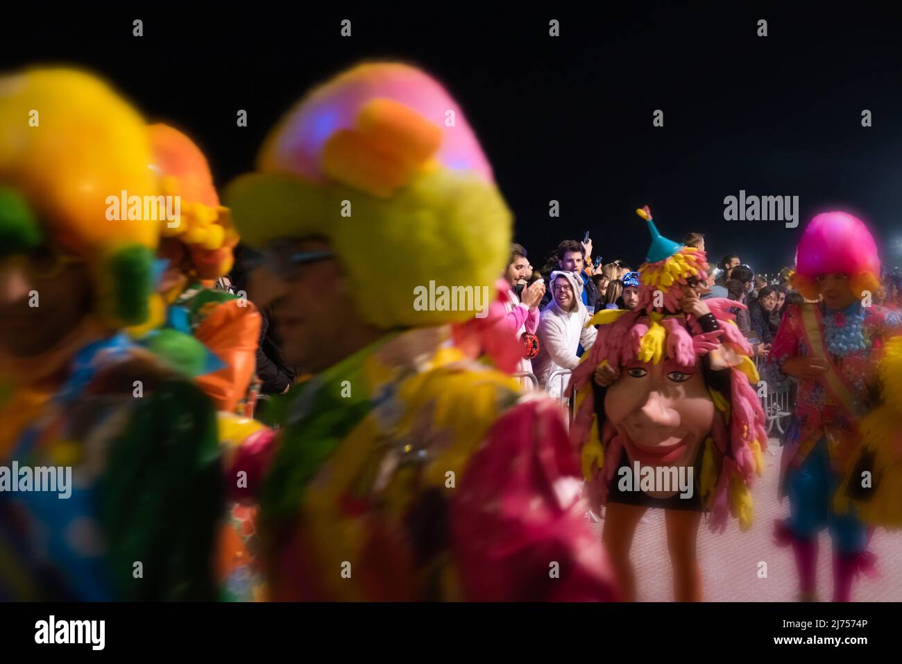 Selektiver Fokus in der Menge: Ein lächelnder Junge, in einem lustigen Kostüm verkleidet, teilt seine Begeisterung für die surrealistische Karnevalsparade in Sitges, Spanien Stockfoto