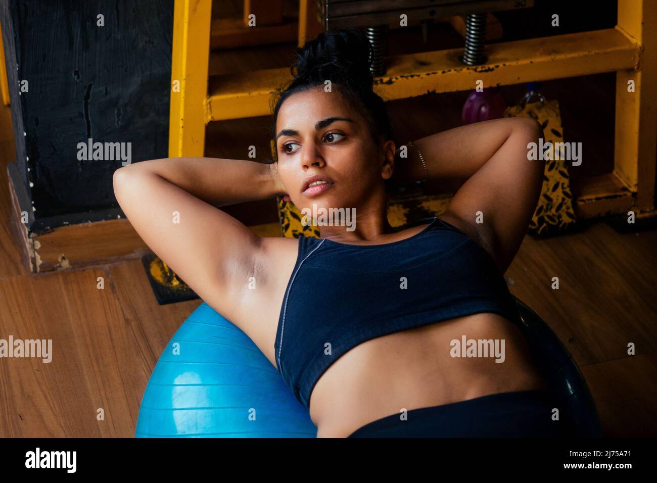 indische Frau macht Pilates und Balance-Übungen Gymnastikball Stockfoto