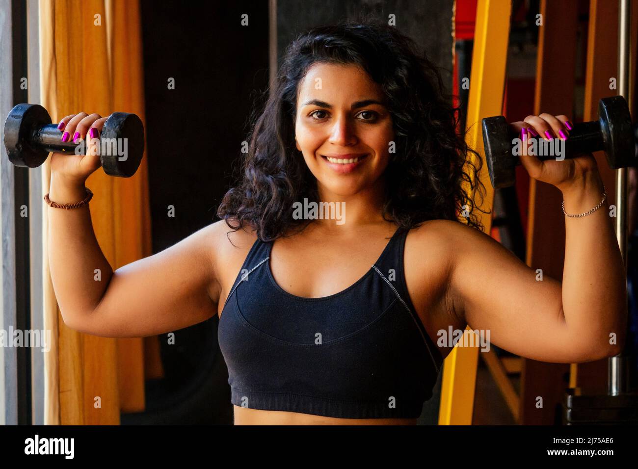 hispanic latein Locken Haare american Frau macht direkten Hit mit Hanteln  Körper positiv Stockfotografie - Alamy