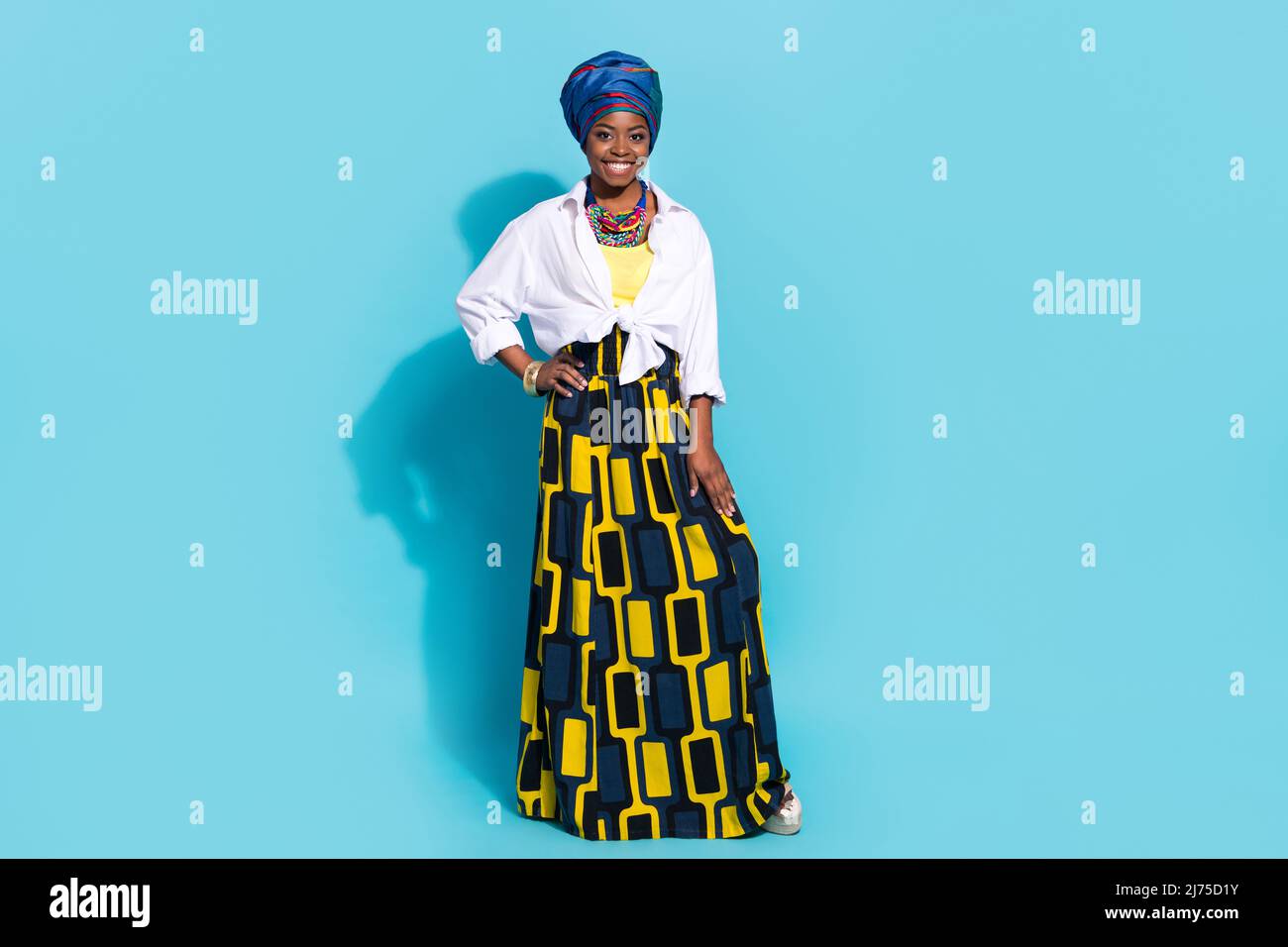 In voller Länge Foto von niedlichen Dame stehend lächelnd tragen nationalen masai Outfit isoliert blau Pastellfarben Hintergrund Stockfoto