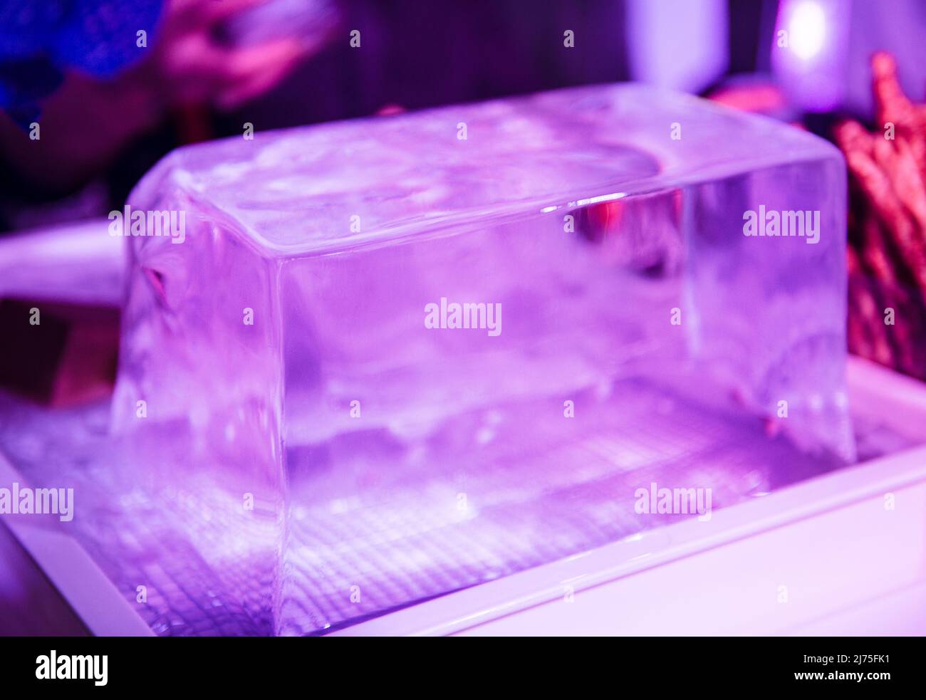 Ein großer Eisblock, der in einem Nachtclub für Cocktails geschnitzt werden soll. Stockfoto