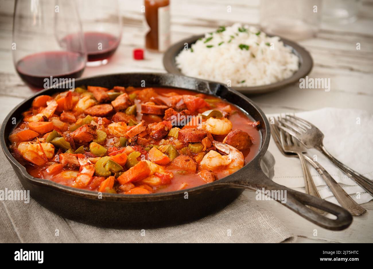 Jambalaya mit Garnelen und Wurst, Reis und Rotwein Stockfoto