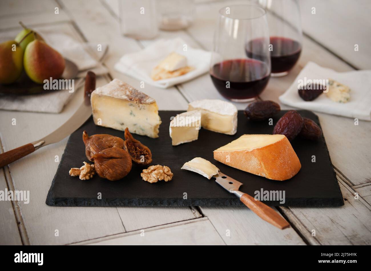 Verschiedene Gourmet-Käsesorten mit Feigen, Nüssen, Datteln und Wein Stockfoto