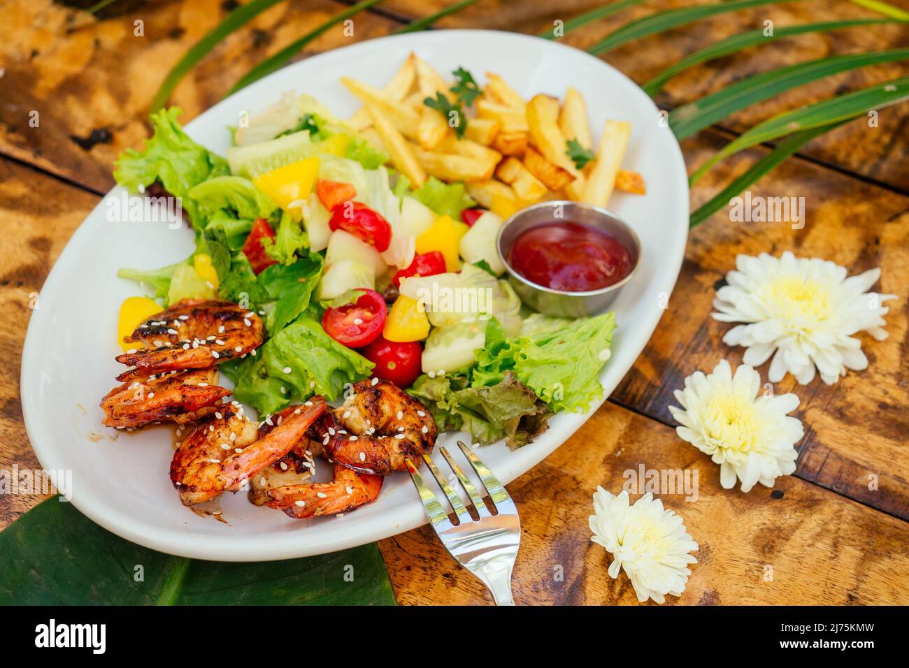 Gegrillte Garnelen und gebratene Kartoffeln auf dem Teller oben Stockfoto