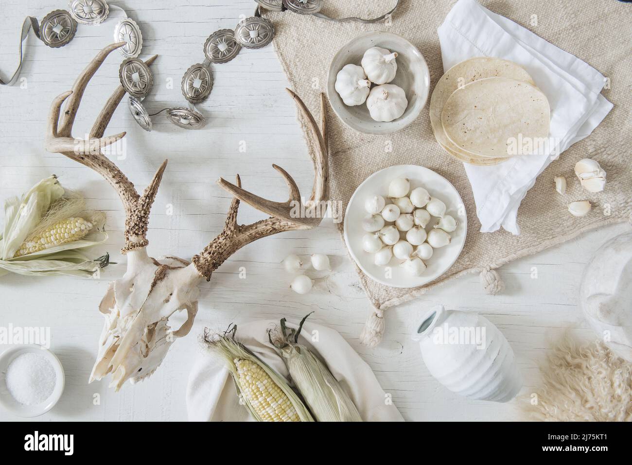 Ein Arrangement aus weißem Mais, Tortillas, Knoblauch, eingelegten Zwiebeln und südwestlichen Antiquitäten Stockfoto