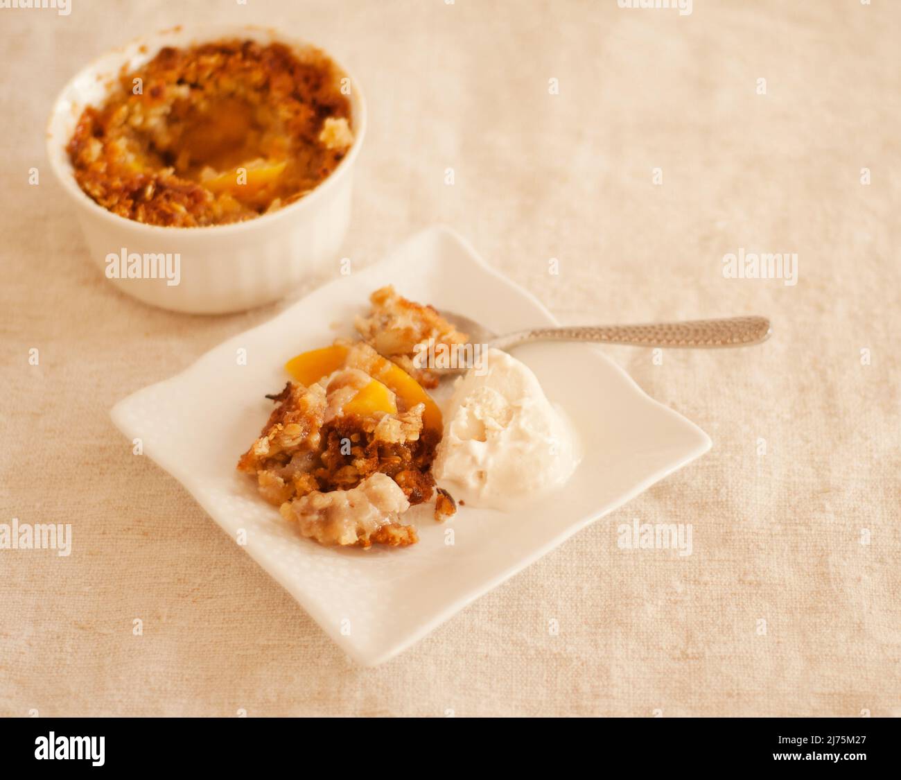 Servieren von Pfirsich-Cobbler auf einem Teller mit Vanilleeis Stockfoto