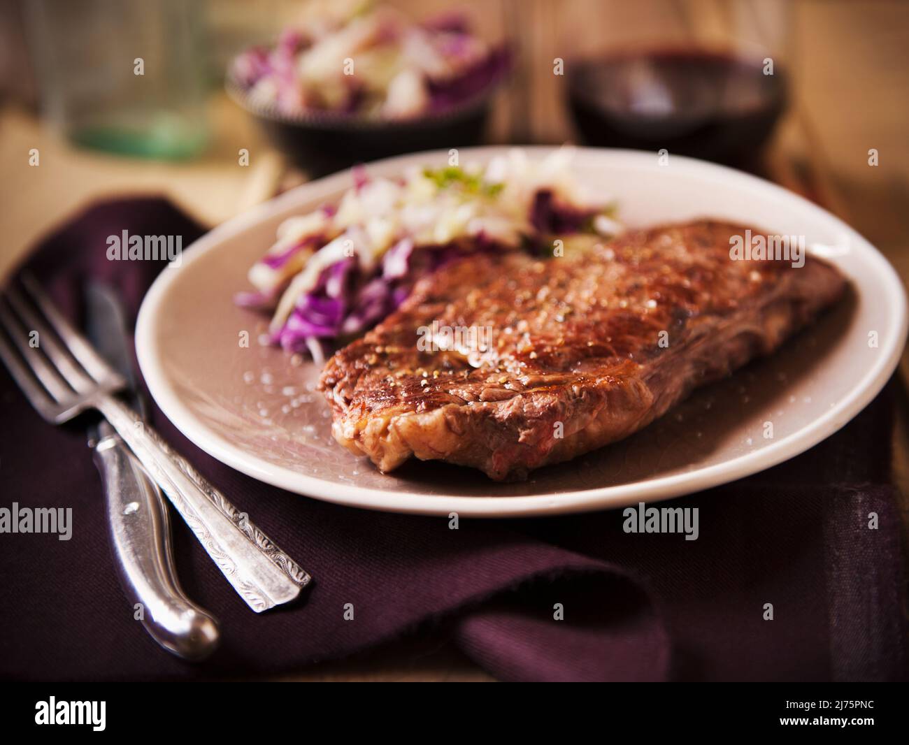 Grass Fed Rib-Eye Steak serviert mit Kochsalat und Rotwein Stockfoto