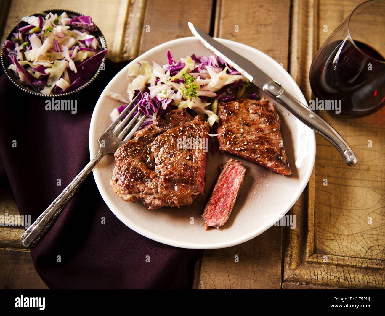 Grass Fed Rib-Eye Steak mit Slaw und Rotwein; auf einem Teller; von oben Stockfoto