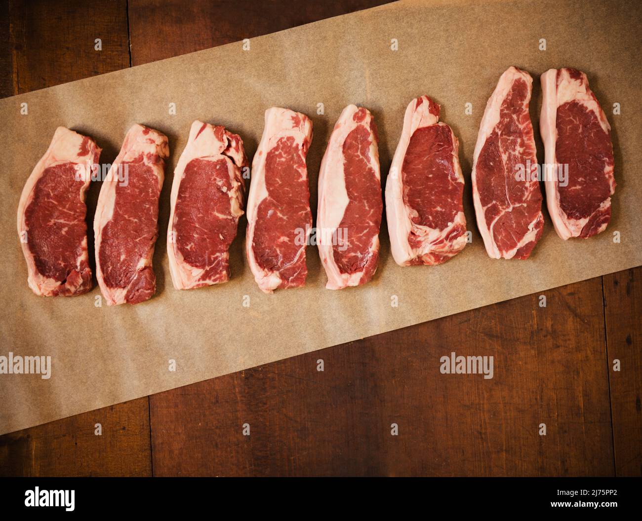 RAW Grass Fed New York Strip Steaks auf Pergament Paper Stockfoto