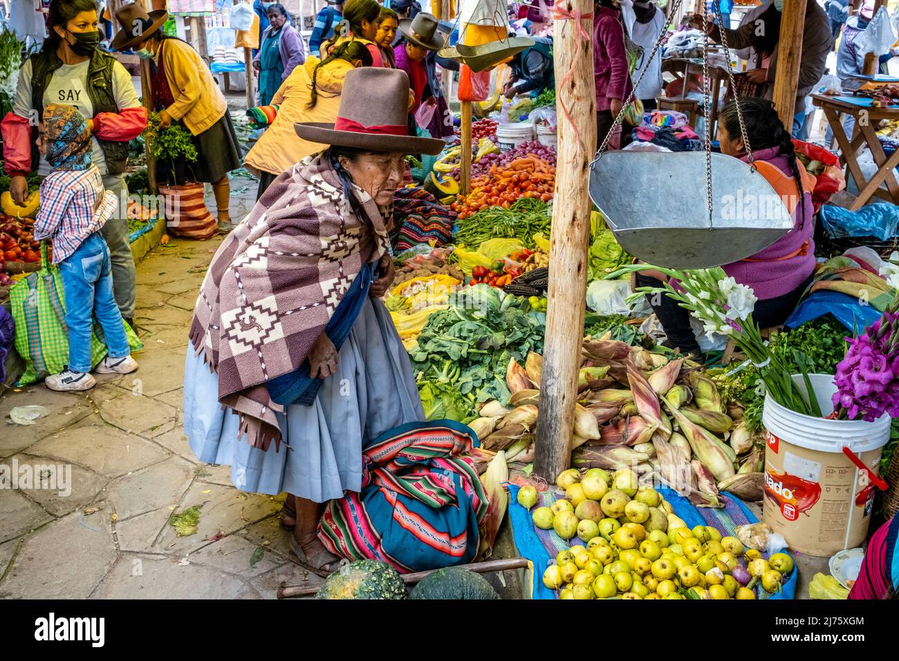 Ältere indigene Quechua-Frauen, die auf dem Sonntagsmarkt im Dorf Chinchero, Region Cusco, Peru, Obst und Gemüse einkaufen. Stockfoto