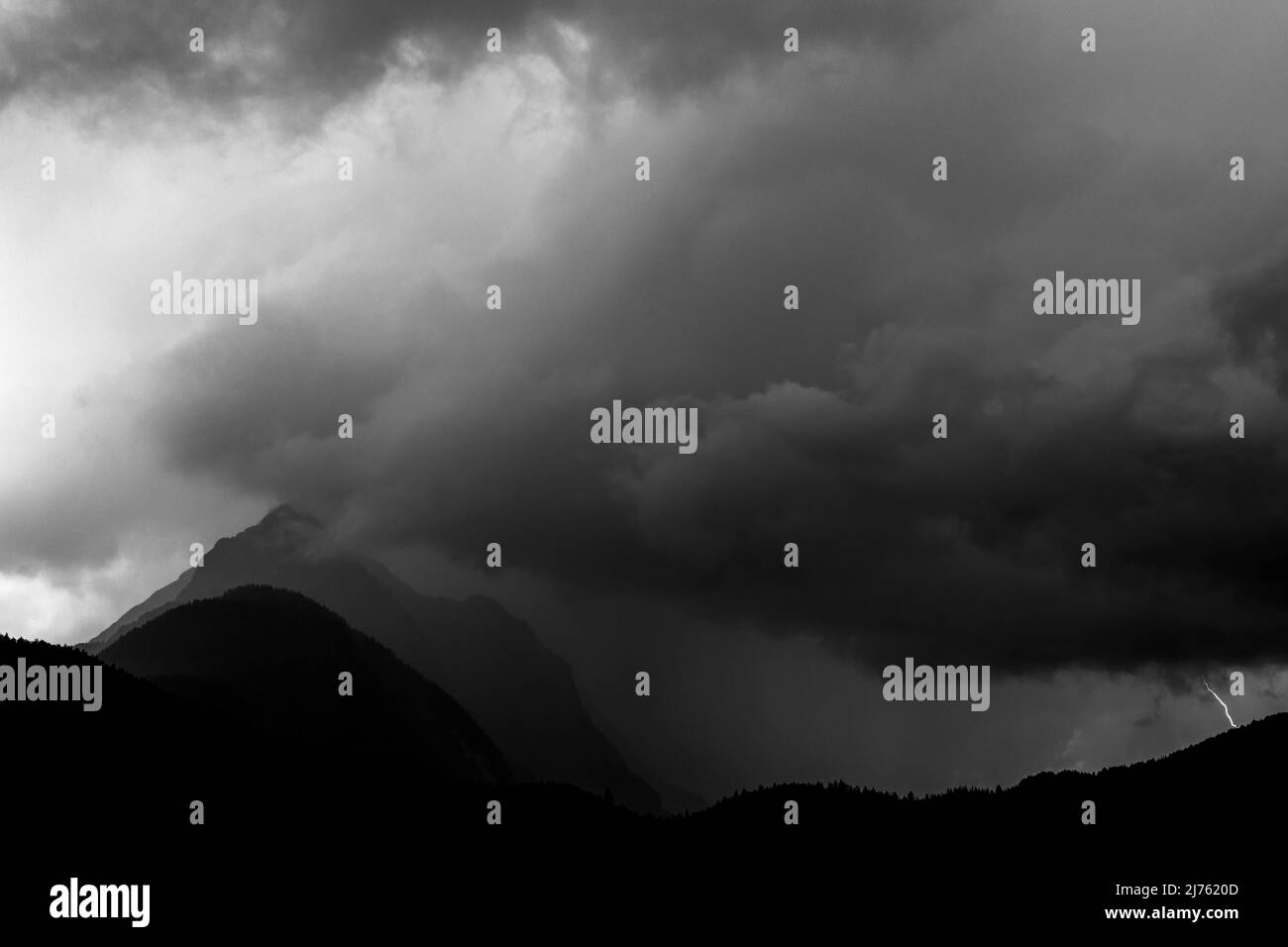 Gewitter mit kleinem Blitzschlag bei Ferchensee und dunklen Wolken bei Wetterstein Stockfoto