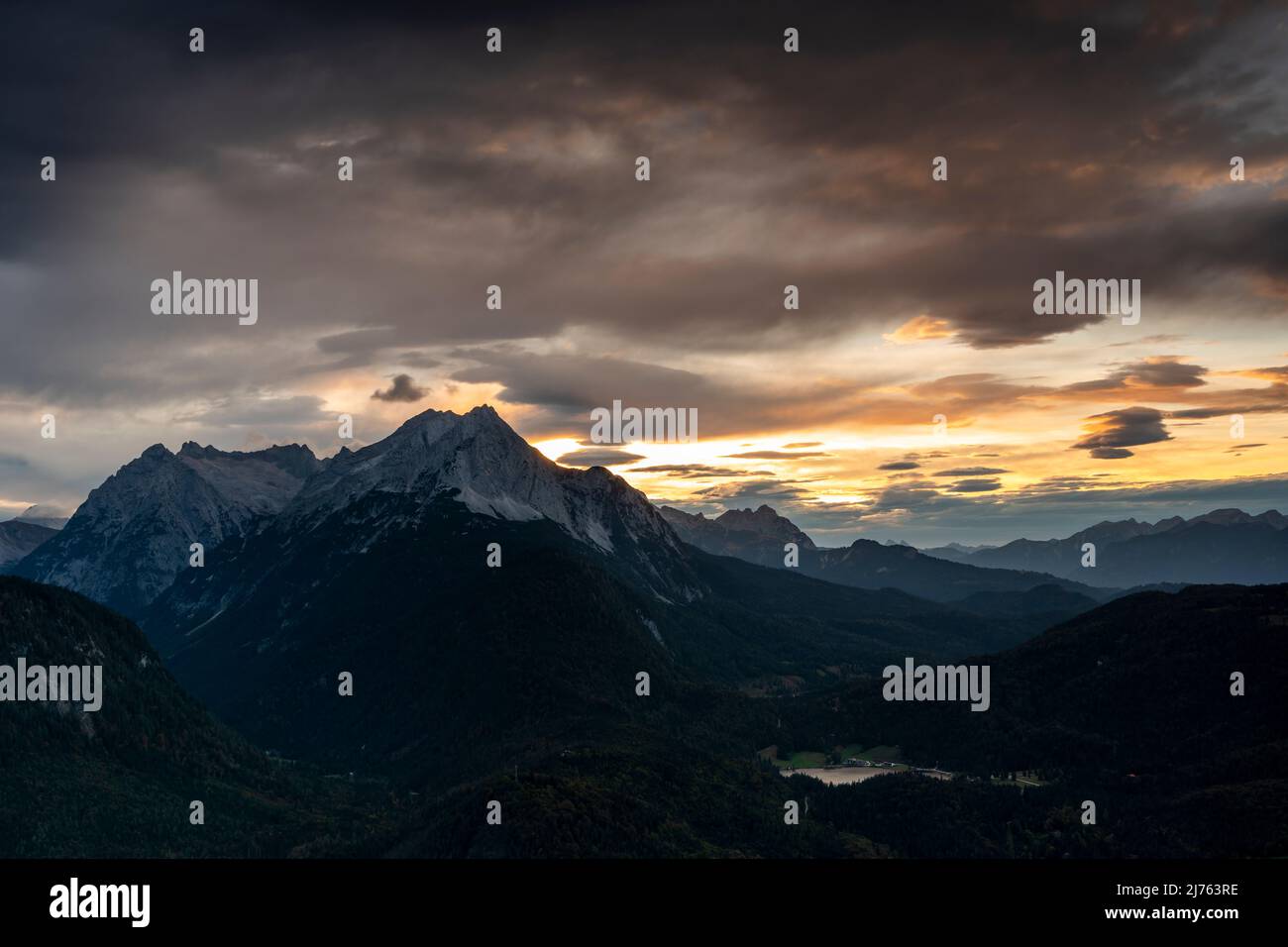 Blick von der Mittenwalder Hütte auf die Wettersteinberge und den Lautersee bei Mittenwald im bayerischen Voralpenland am Abend rot mit dramatischen Wolken. Stockfoto