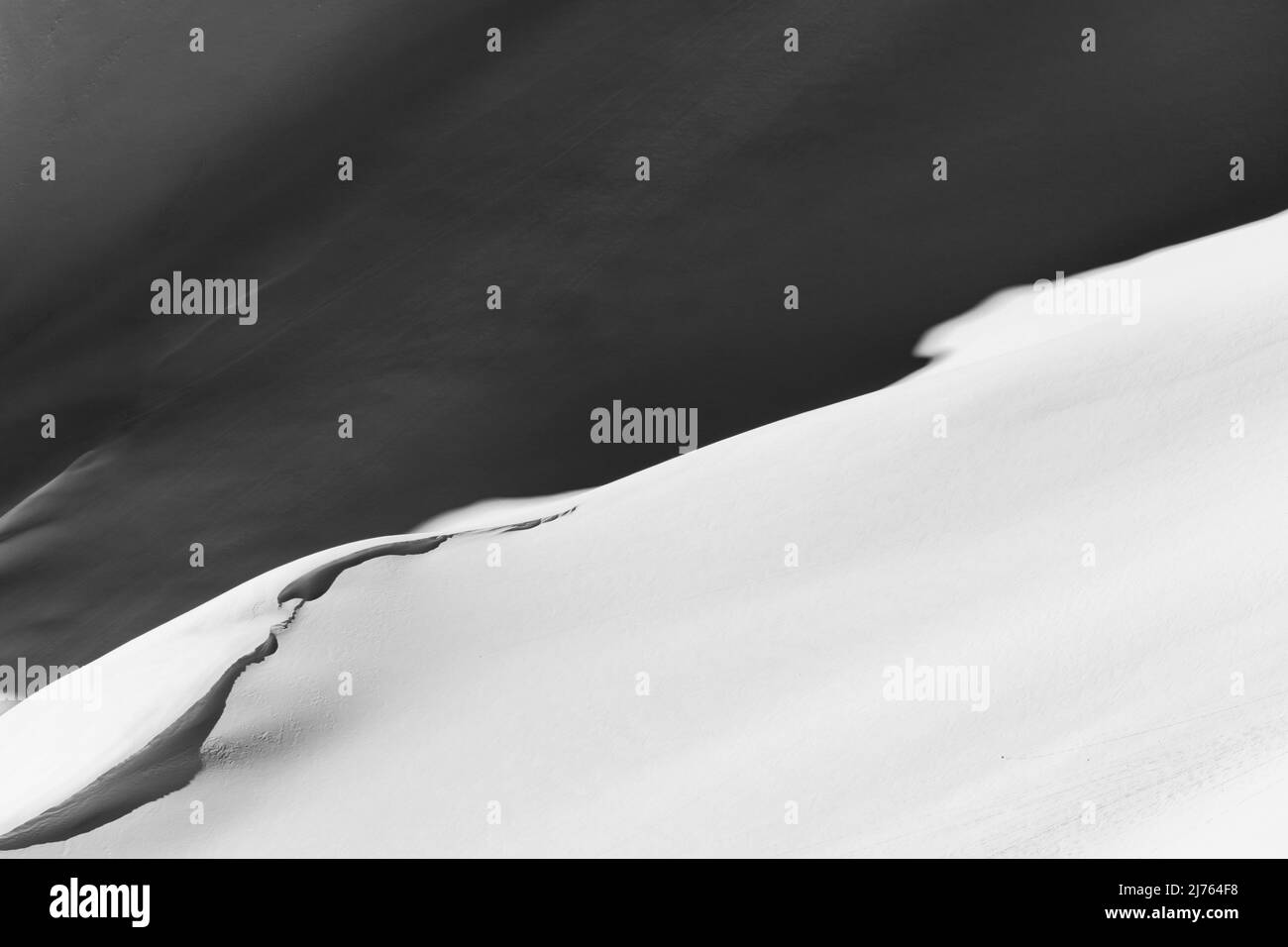 Eine Düne, oder Schnee- und Eiswelle, mit Licht und Schatten an den Hängen der Westlichen Karwendelspitze oberhalb von Mittenwald bei Wintersonne. Stockfoto