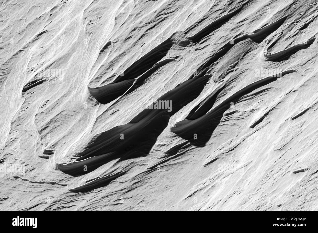 Formen und Strukturen im harten Licht und Schatten am Berghang in Karwendel, im Winter Stockfoto