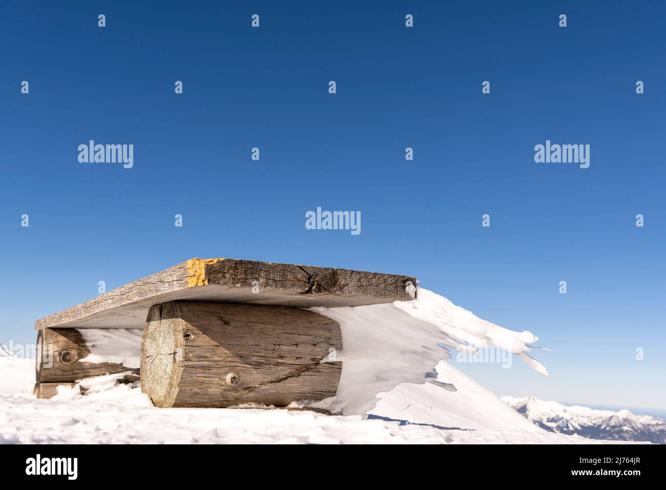 Eine Bank an der Bergstation der Karwendelbahn am Westkarwendel, in Schnee und Eis, mit bizarren Eiszapfen, die horizontal vom Sitz weg gehen. Stockfoto