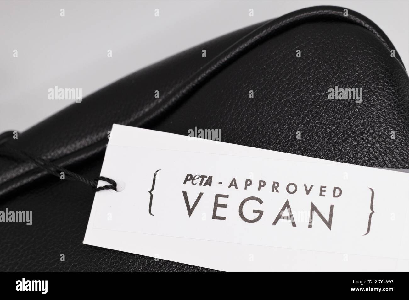 Ein „Peta Approved“-Etikett mit „vegan“-Aufschrift auf einer Geldbörse aus Kunstleder. Stockfoto