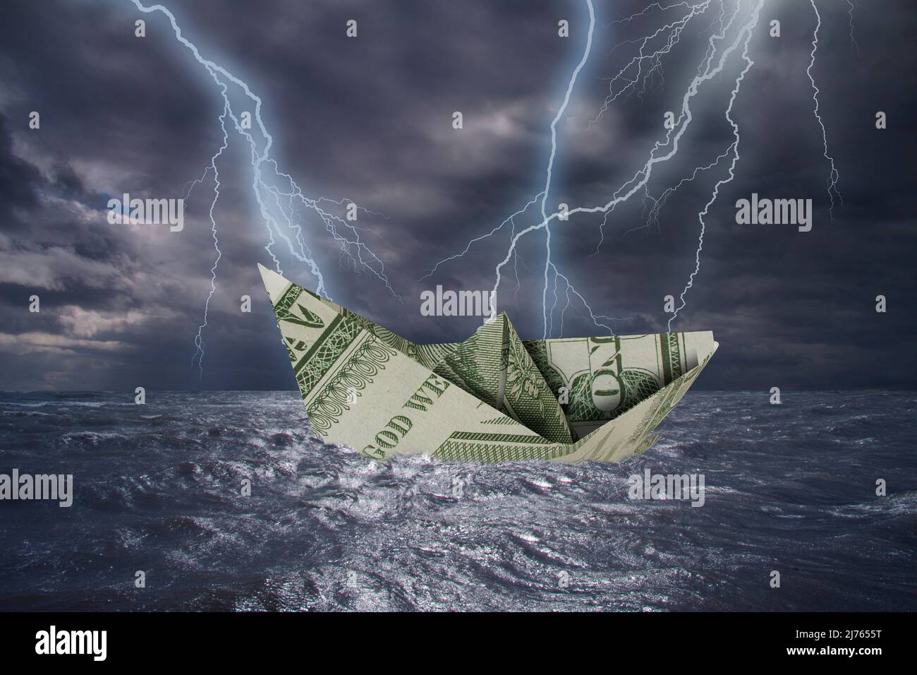 Papierboot aus einer 1-Dollar-Note kentert fast in hohen Wellen und Blitzschlag über stürmisch dunklem Meer während eines Gewitters mit dramatischem c Stockfoto