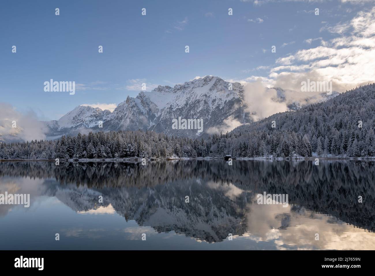 Winter am Lautersee mit Schnee und Spiegelung des Karwendelgebirges oberhalb von Mittenwald am Nachmittag im Winter. Stockfoto