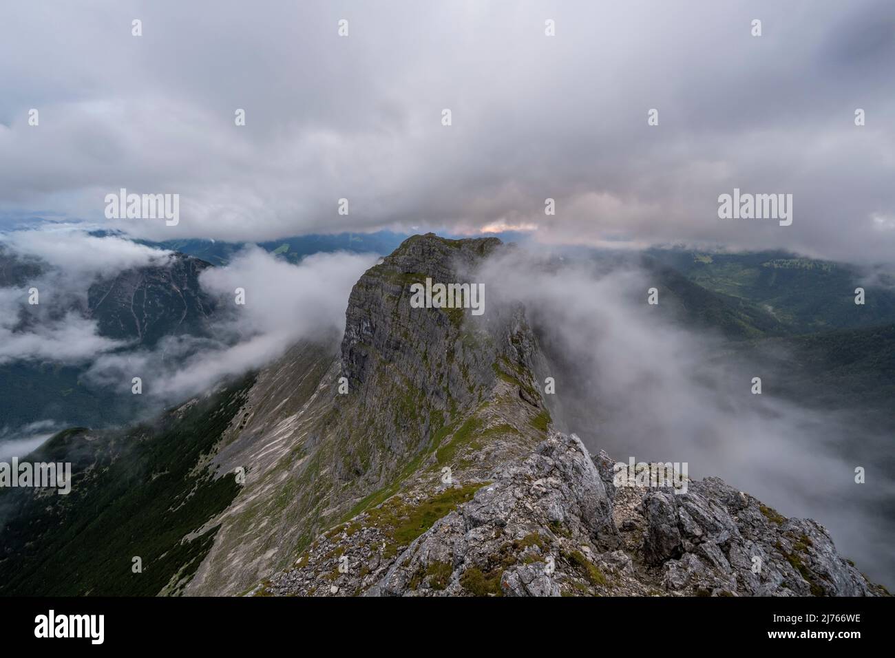 Der Grat zwischen den beiden Guffertspitzen mit viel losem Gestein bei schlechtem Wetter während des Sonnenuntergangs, Nebel und Wolken dominieren das Bild. Stockfoto