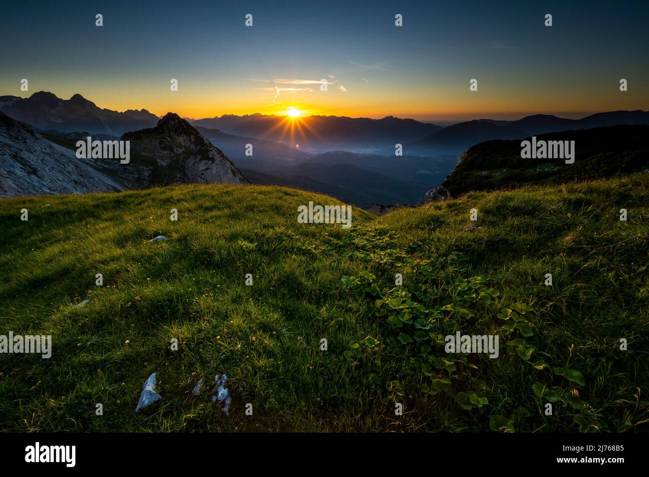 Sonnenuntergang in Richtung Garmisch-Partenkirchen, vom Gamsanger unterhalb des Wettersteingebirges, mit Blick auf die Zugspitze und die Ammergauer Alpen. Stockfoto