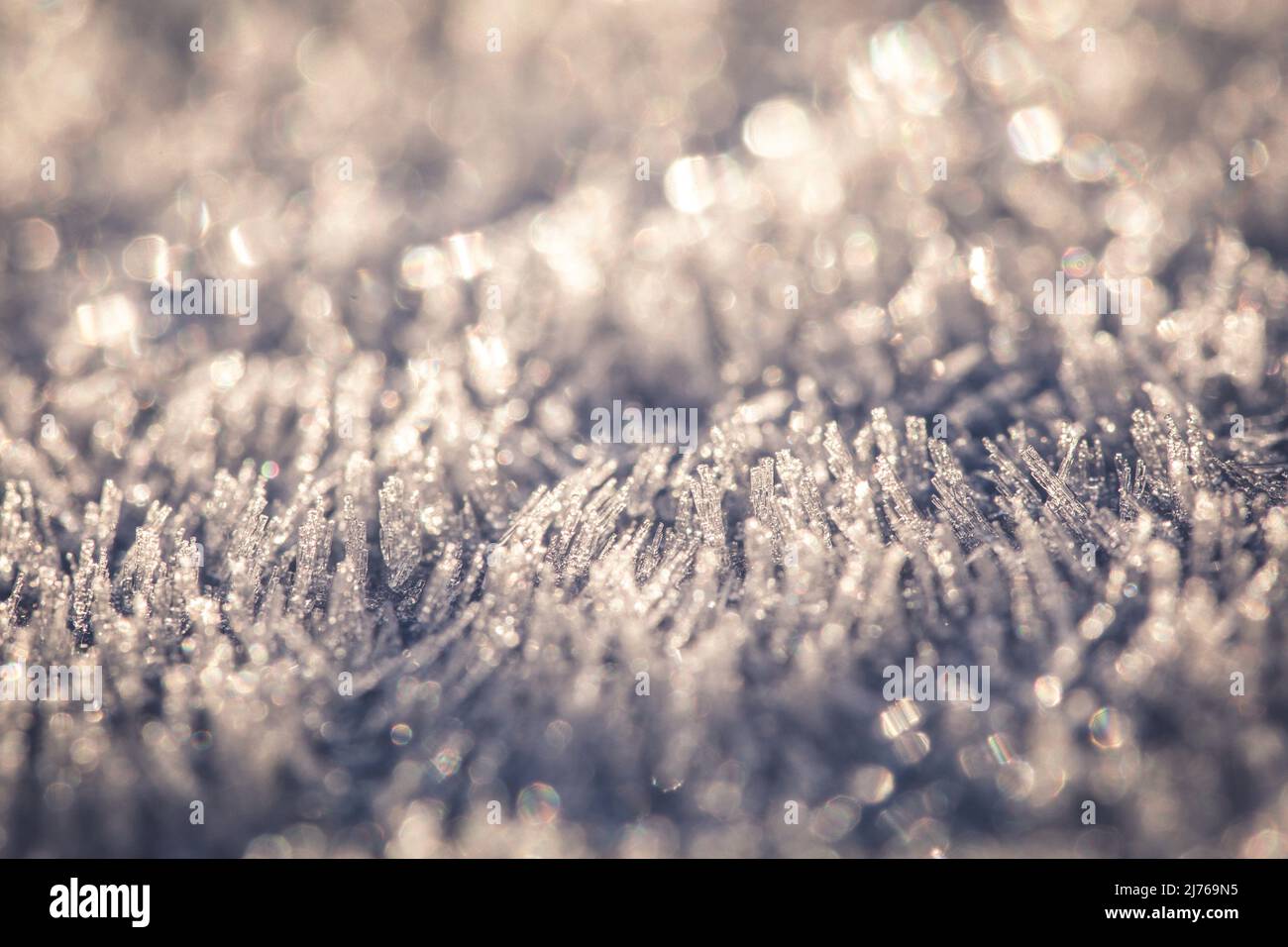 Schneeoberfläche, Eiskristall von der Sonne beleuchtet, Nahaufnahme, Unschärfe Stockfoto