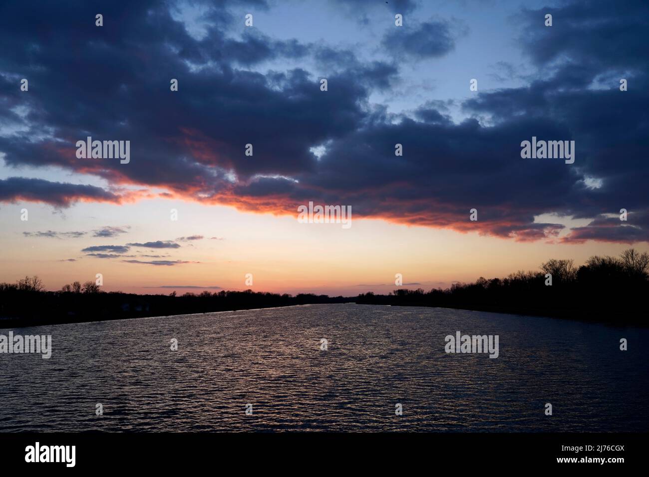 Deutschland, Bayern, Oberbayern, Altötting, Neuötting, Sonnenuntergang im Inn, dunkle Wolken, windig Stockfoto