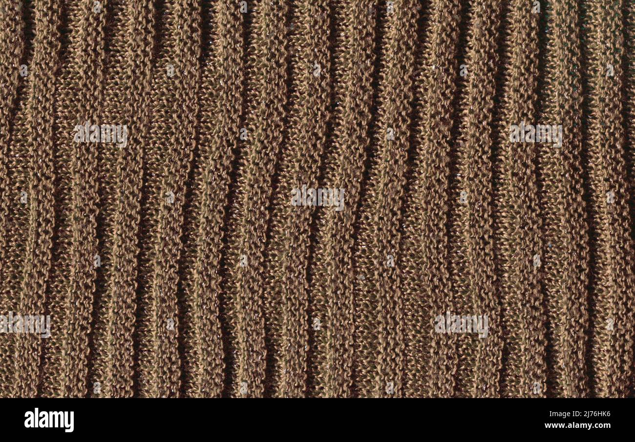 Sandfarbener, kuscheliger Strickpullover aus natürlicher Wollstruktur. Warmer blassbrauner Strickwollhintergrund. Stockfoto