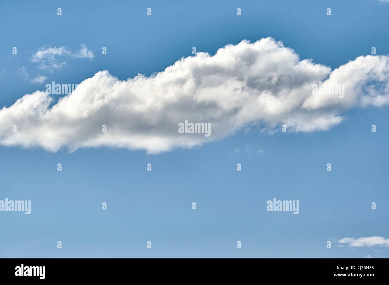Isolierte Wolken auf einem klaren Himmel von einer starken blauen Farbe Stockfoto