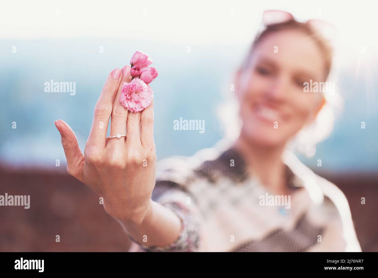 Junge weiße Frau hält Kirschblüte im Frühling, selektiver Fokus, Schärfentiefe Stockfoto