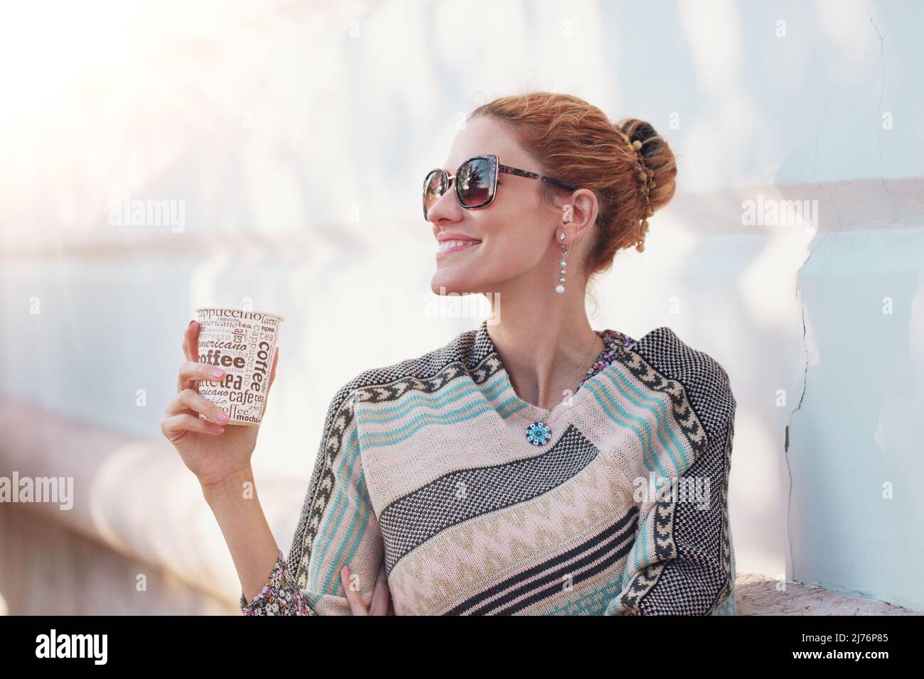 Junge fröhliche trendige 30s Rotschopf kaukasische Frau hält Kaffee im Freien Stockfoto