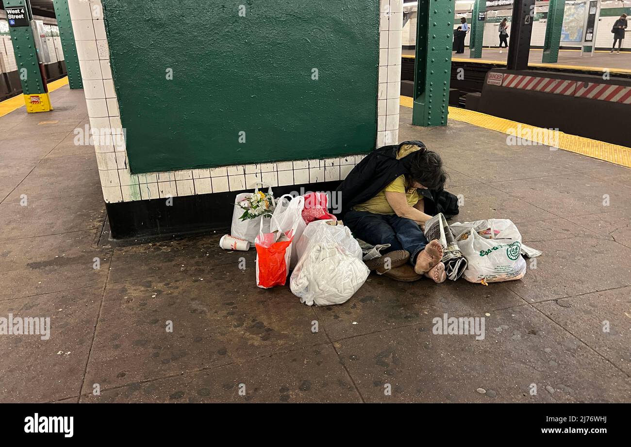 Auf dem Bahnsteig der West 4. Street in Greenwich Village, New York City, wurde eine obdachlose Frau mit Habseligkeiten zerschellt. Stockfoto
