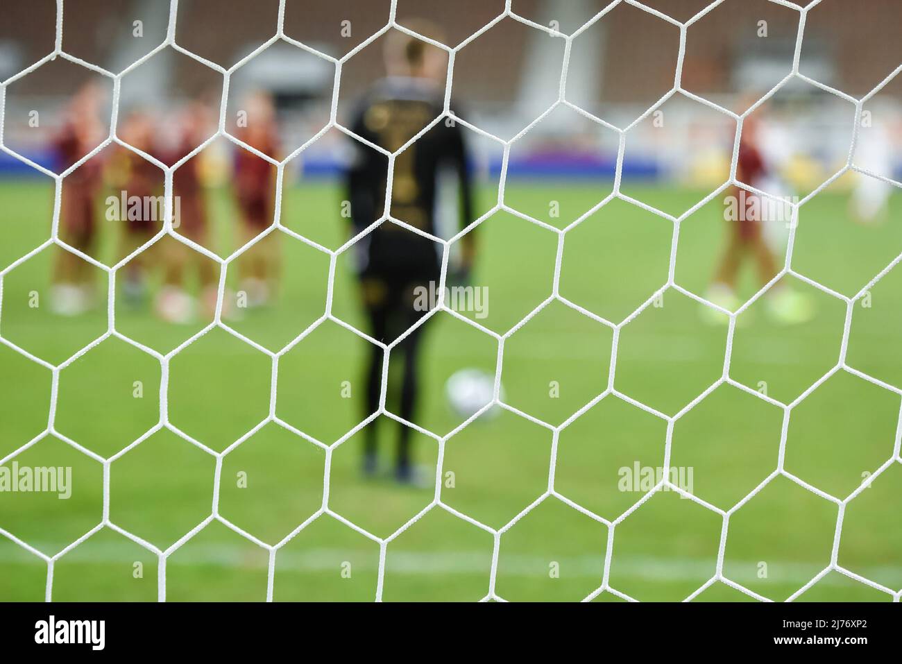 NET im Fußballtor mit Spielern vor Elfmeterschießen im Hintergrund. Stockfoto