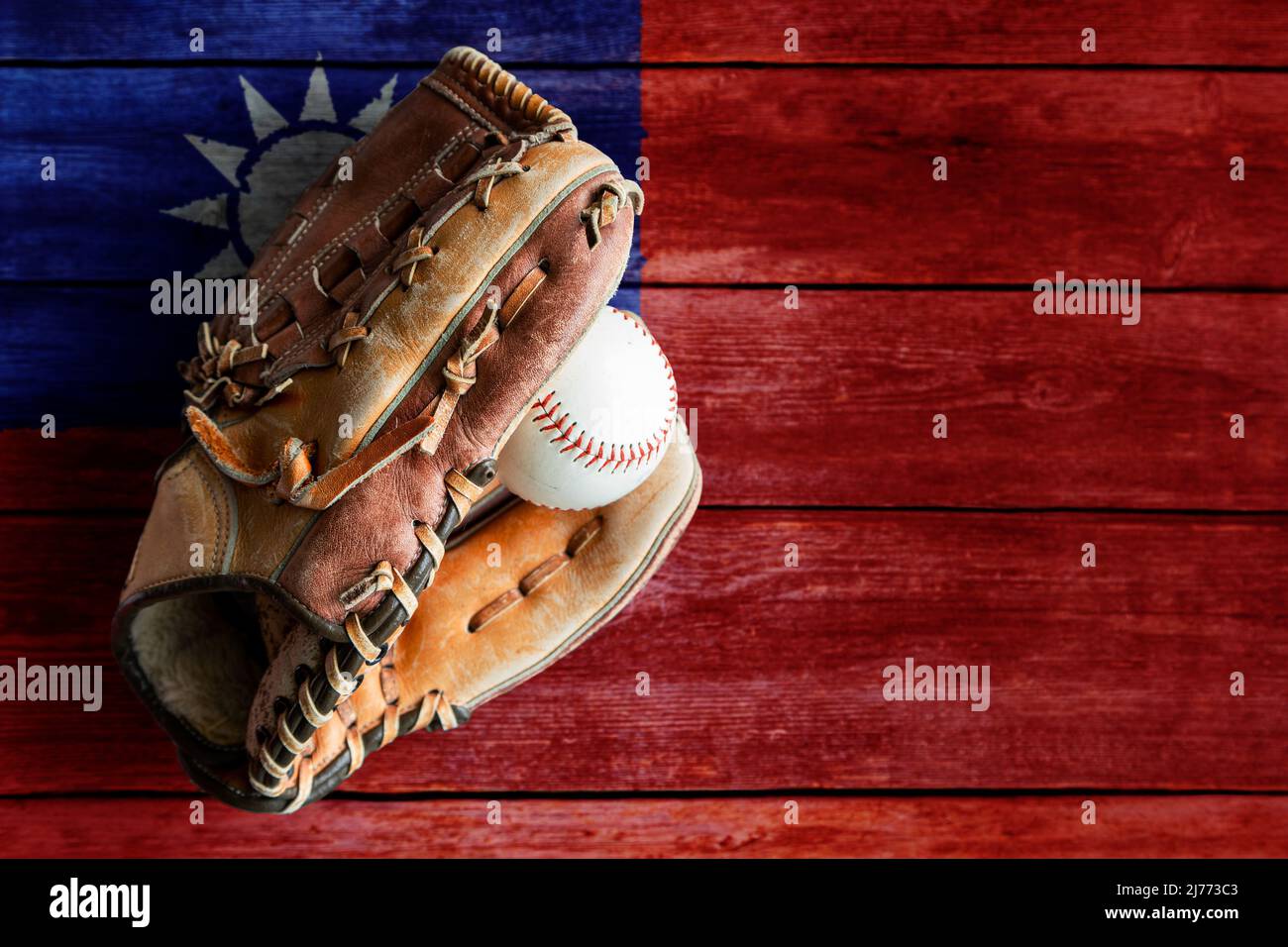 Baseballhandschuh aus Leder mit Ball auf rustikalem Holzhintergrund mit bemalter taiwanesischer Flagge und Kopierraum. Taiwan, auch bekannt als chinesisches Taipeh, ist eines davon Stockfoto