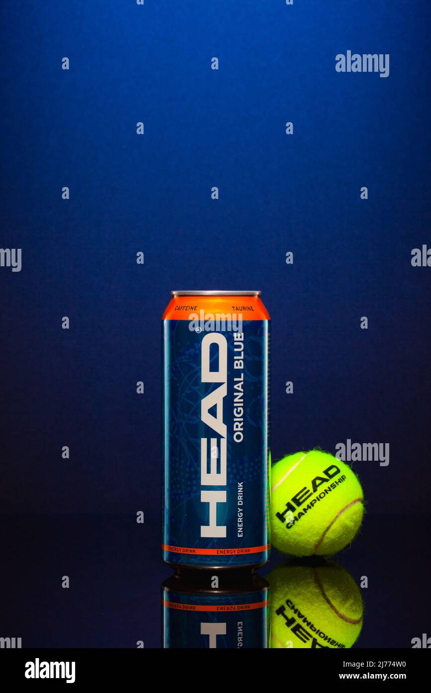 Prag, Tschechische Republik - 23. März 2022: HEAD Energy Drink und gelber Tennisball auf blauem Hintergrund. HEAD Energy Drinks enthalten Koffein und Taur Stockfoto