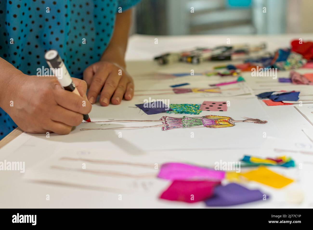 Nahaufnahme einer Modedesignerin, die Skizzen auf ihren Schreibtisch zeichnet Stockfoto
