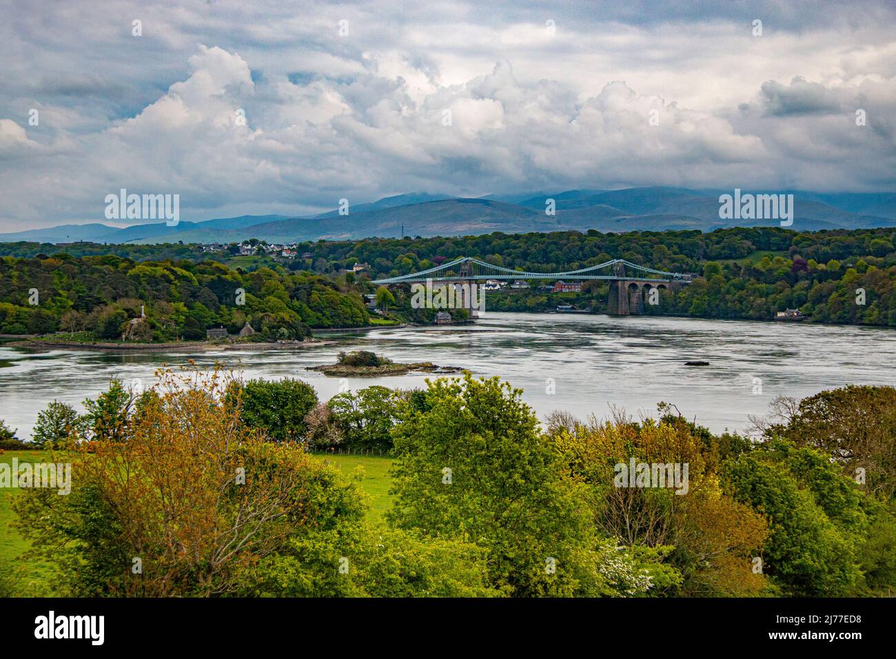 Die Menai-Hängebrücke über den Menai, die von Thomas Telford entworfen wurde, um das Festland mit der Insel Anglesey in Nordwales zu verbinden Stockfoto