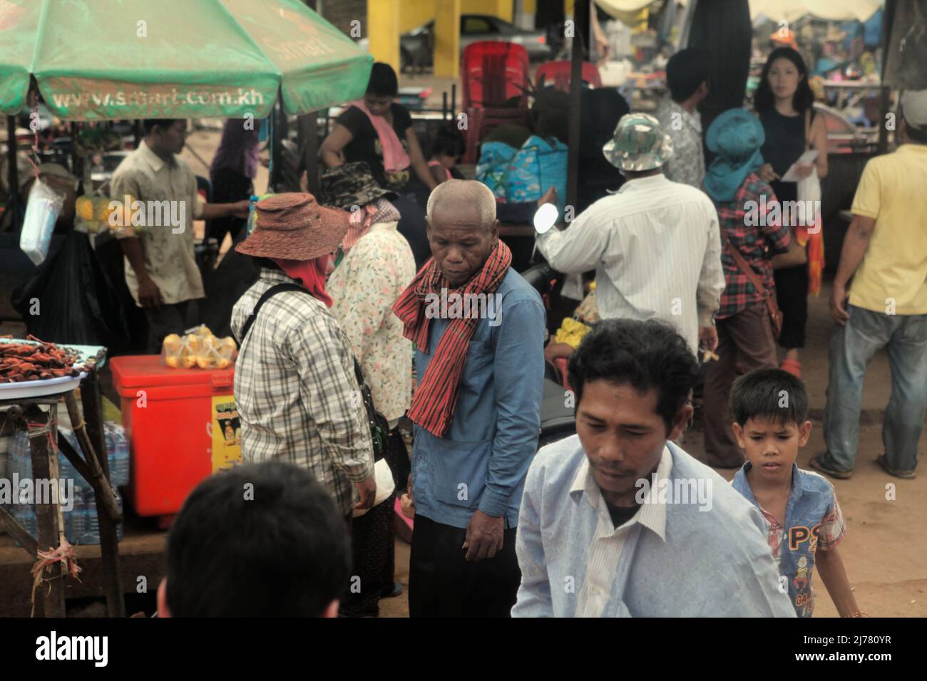Menschenmassen auf einem Straßenmarkt vor einer Intercity-Bushaltestelle, fotografiert von einem Bus in der Nähe von Kampong Cham, Kambodscha. Stockfoto