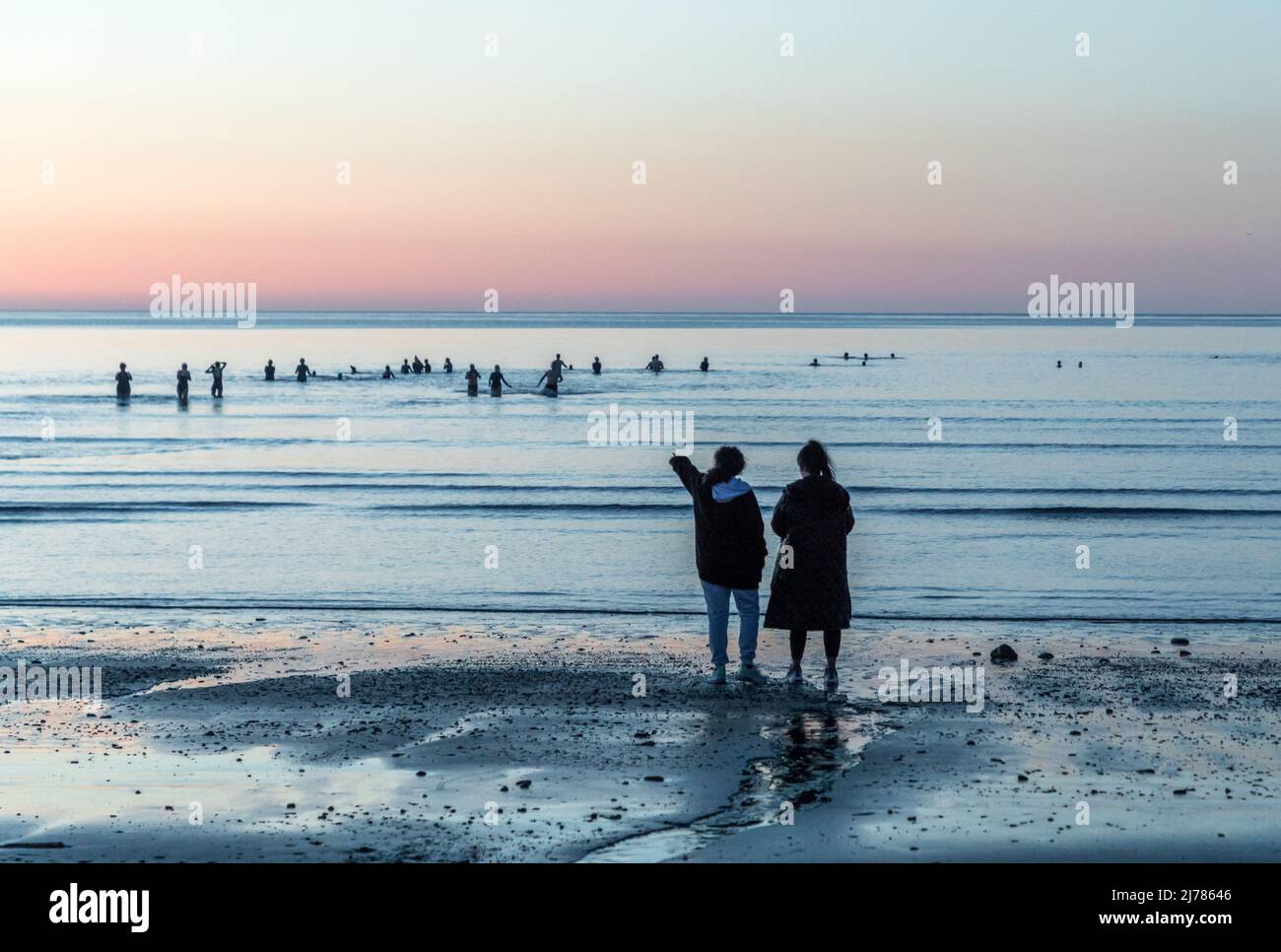 Fountainstown, Cork, Irland. 07.. Mai 2022. Laila Dennehy und Saiama Raja aus Crosshaven beobachten Schwimmer im Morgengrauen, die an der „Darkness into Light Swim“-Veranstaltung teilnehmen, bei der Geld für Pieta House in Fountainstown, Co. Cork, Irland, eingesammelt wird. - Credit; David Creedon / Alamy Live News Stockfoto