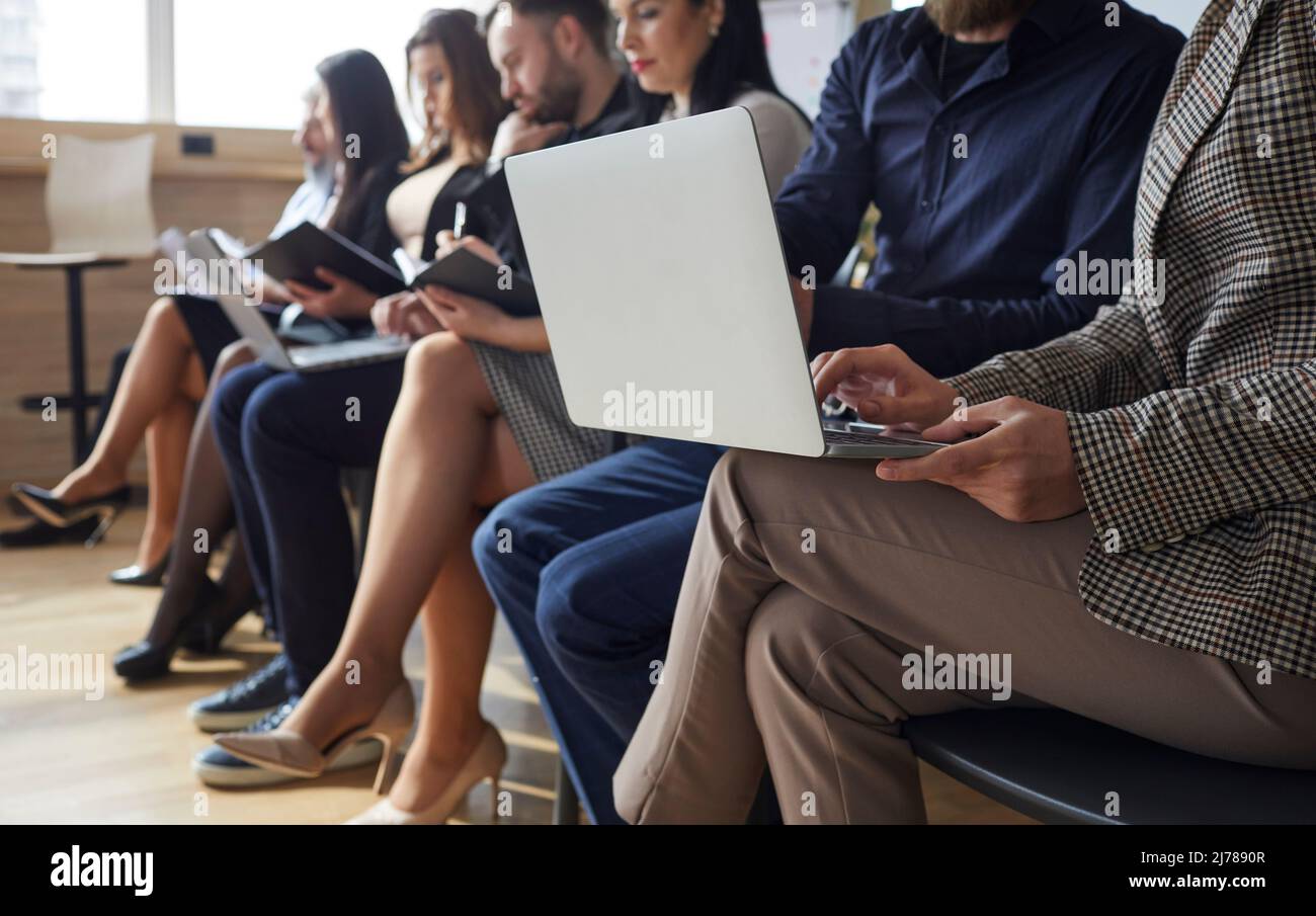Geschäftsleute oder Firmenmitarbeiter, die im Büro sitzen und an Laptops arbeiten Stockfoto