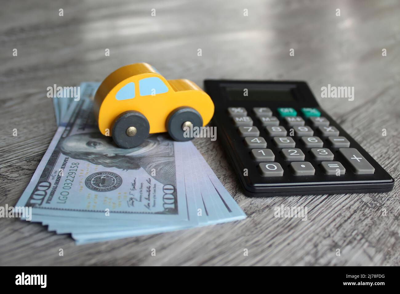 Spielzeugauto, Geldscheine und Taschenrechner mit Platz für Text. Finanzen, Kfz-Versicherung, kaufen, verkaufen. Stockfoto