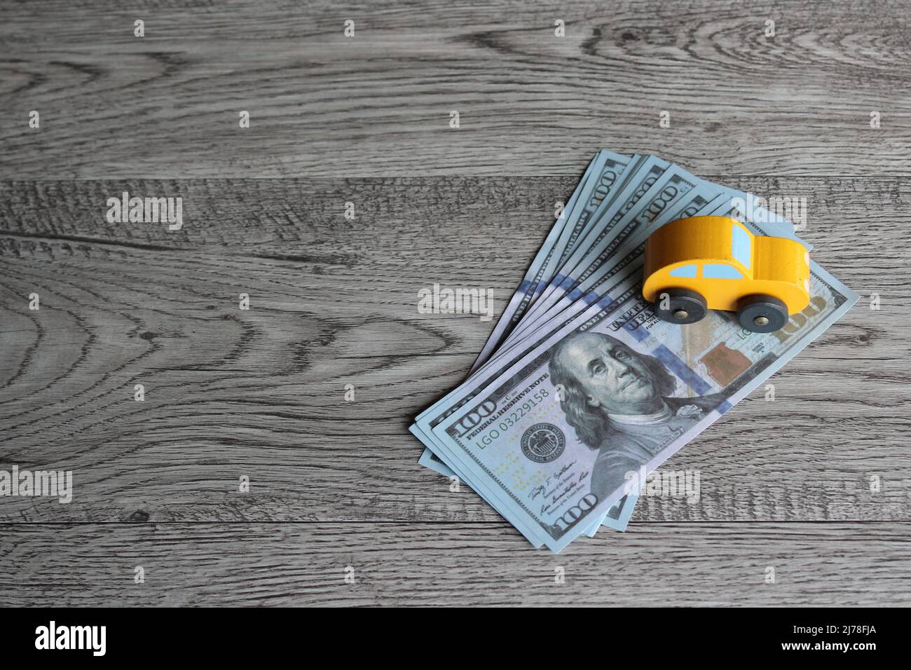 Spielzeugauto und Banknoten mit Platz für Text. Finanzen, Kfz-Versicherung, kaufen, verkaufen, mieten und reparieren. Stockfoto