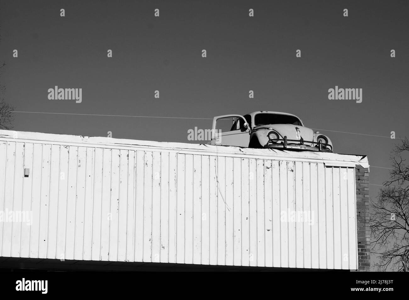 Vintage Volkswagen Käfer klebte auf dem Dach des lokalen Geschäfts. Stockfoto