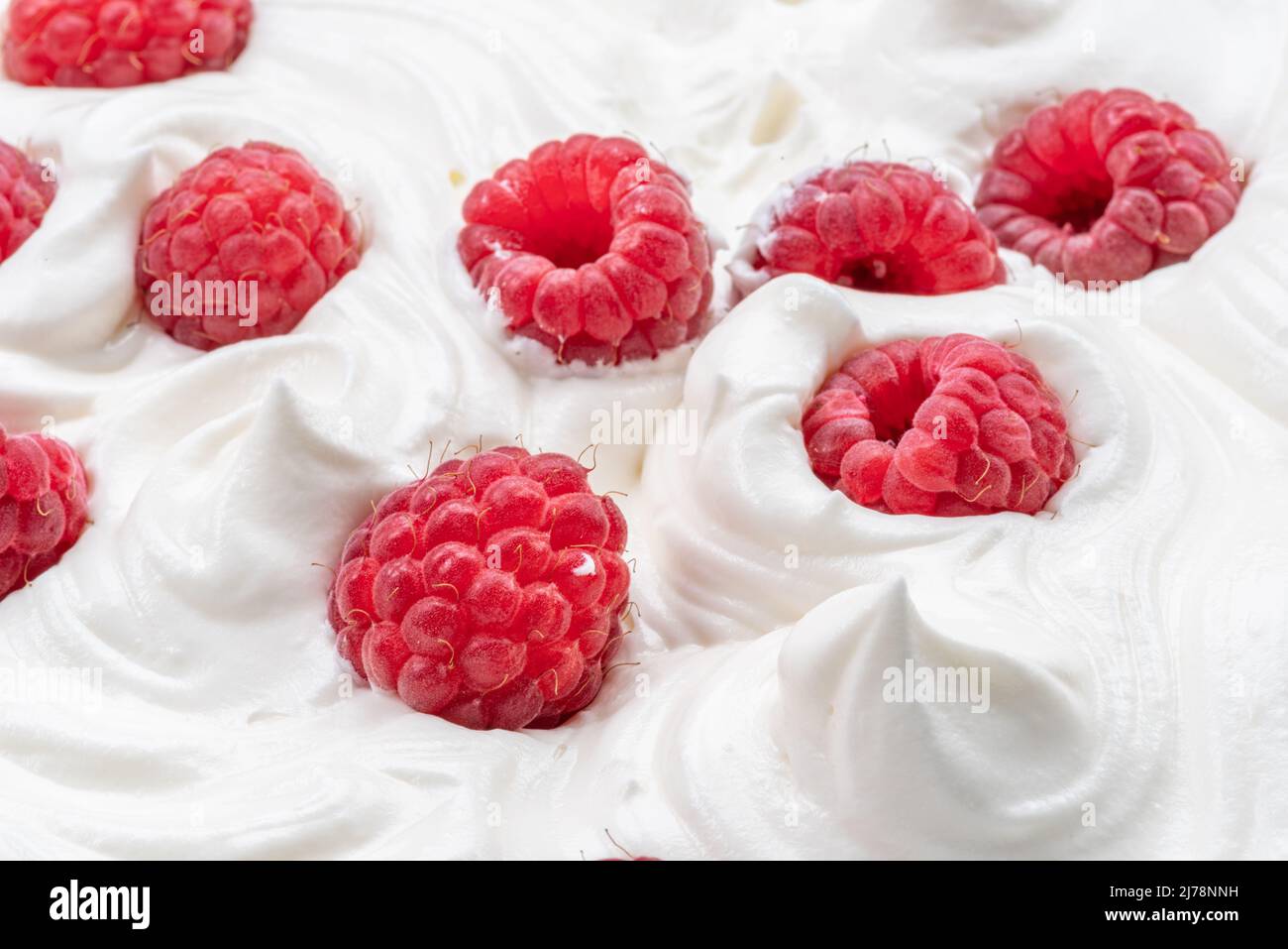 Frische Himbeeren im Joghurt oder in der Creme. Draufsicht. Stockfoto