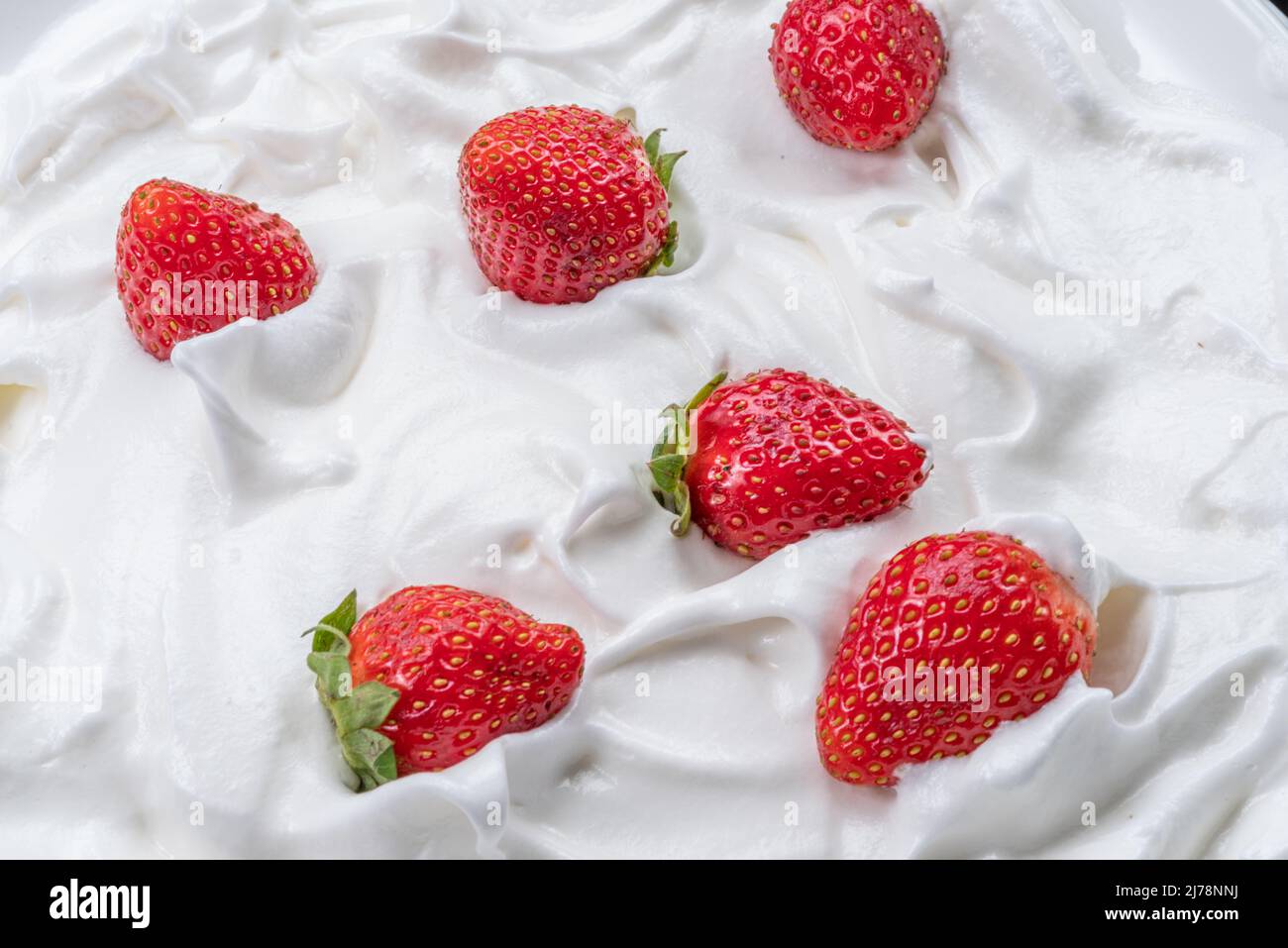 Frische Erdbeeren im Joghurt oder in der Creme. Draufsicht. Stockfoto