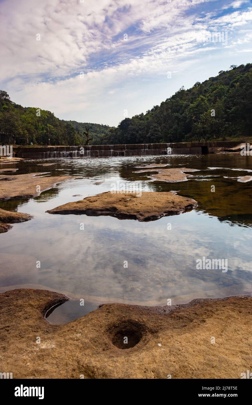 Flussbett Steinloch mit Wasser und umgeben von grünen Wäldern aus flachem Winkel Stockfoto