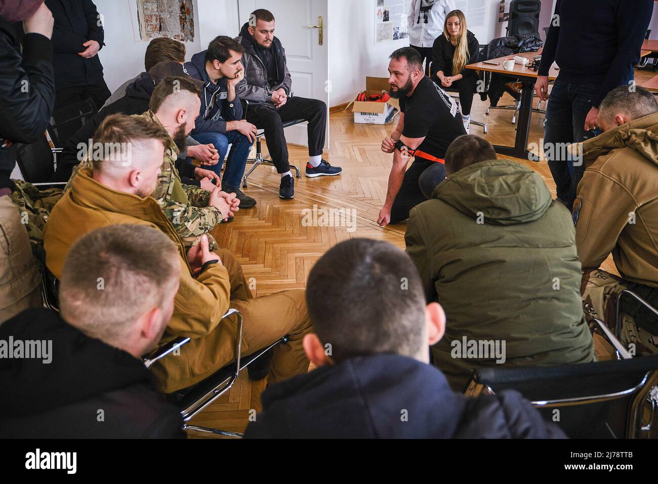 15. März 2022, Warschau, Polen: Ein Schrei ist zu hören; itÃ­s Zeit, sich für die erste-Hilfe-Ausbildung in Konflikten zu versammeln. Jeder dummelt sich in einen Kreis, wie ein polnischer Ex-Kämpfer aus dem Krieg in Afghanistan ihnen eine Illustration seiner Tech- niques gibt. Die meisten dieser Freiwilligen haben keine militärische oder Kampferfahrung. Viele Freiwillige kommen ins weißrussische Haus in Warschau. Es gibt viele, die sich für ein Bataillon entscheiden, das nach Kastus Kalouski benannt ist, einem Schriftsteller und Revolutionär, der im 19.. Jahrhundert die treibende Kraft hinter dem weißrussischen Nationalismus war. Die meisten von ihnen sind sehr jung, einige fast Kinder, aber sie Stockfoto