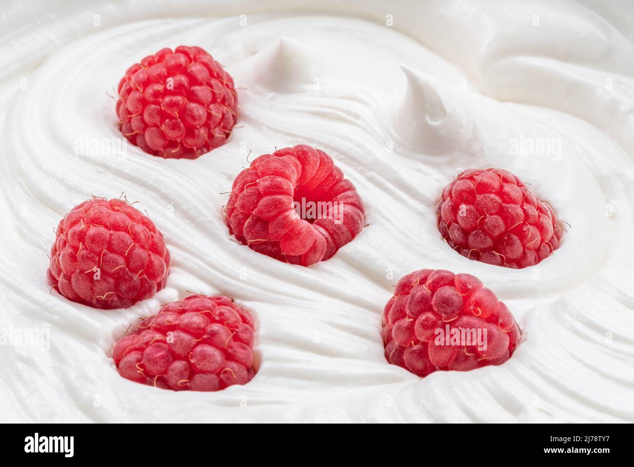 Frische Himbeeren im Joghurt oder in der Creme. Draufsicht. Stockfoto