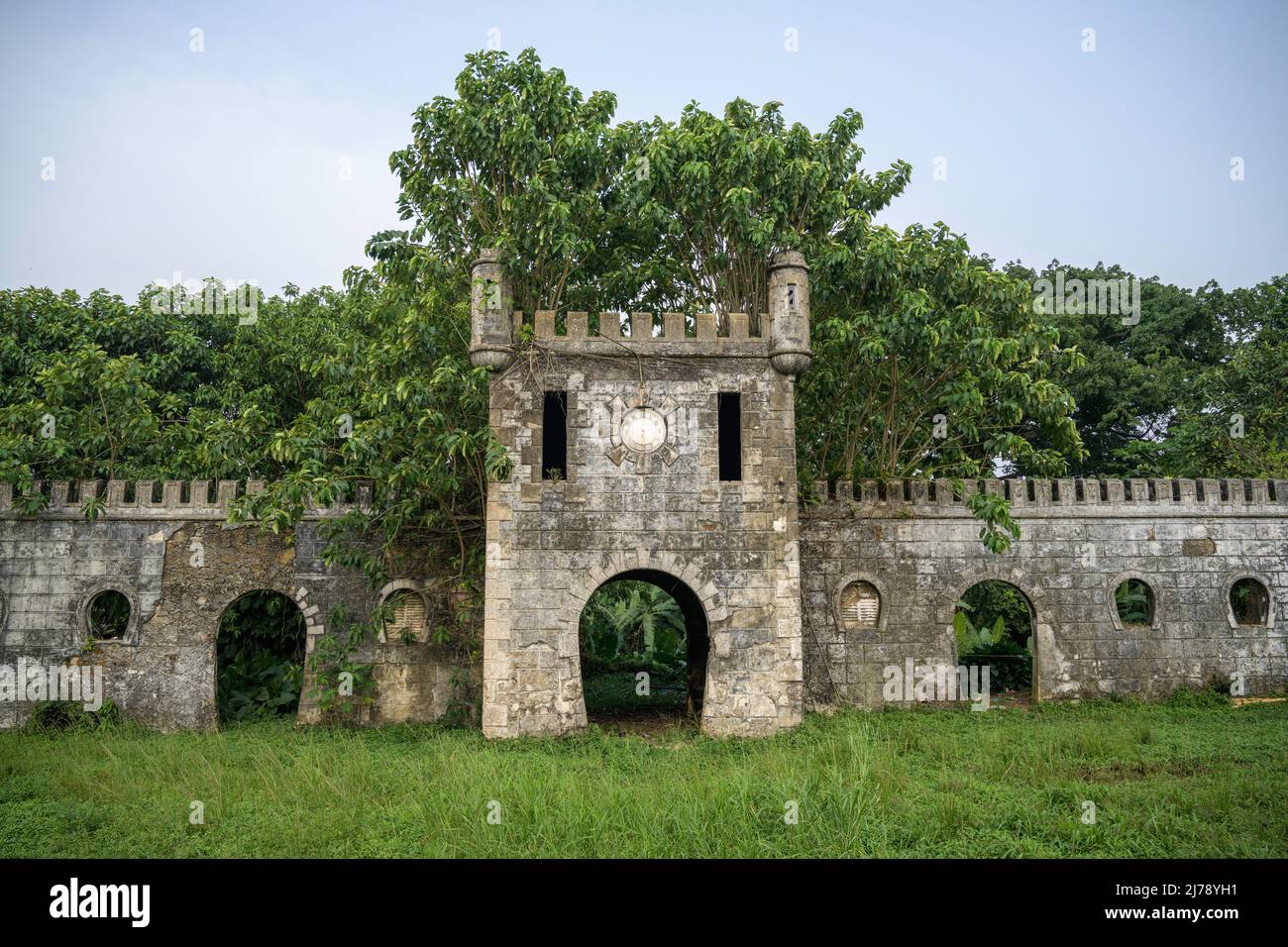 Alte Befestigung der kolonialen Plantage von Roça Sundi, die von Dschungelvegetation gefressen wurde. Stockfoto