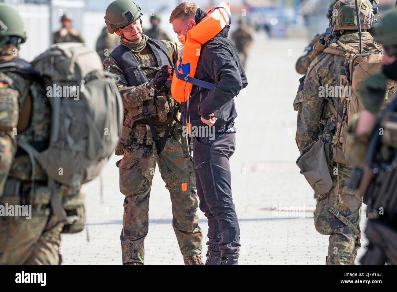 Sassnitz, Deutschland. 7. Mai 2022. 07. Mai 2022, Mecklenburg-Vorpommern, Sassnitz: Zivilisten werden von Soldaten mit Rettungswesten ausgestattet. Die Bundeswehr übt an der Küste Vorpommerns eine Evakuierungsaktion für deutsche Bürger aus einem Krisenland mit 1200 deutschen und niederländischen Soldaten aus. Im Krisenfall sollen deutsche Bürger per Luft und Schiff gerettet werden. Foto: Frank Hormann/dpa Quelle: dpa picture Alliance/Alamy Live News Stockfoto