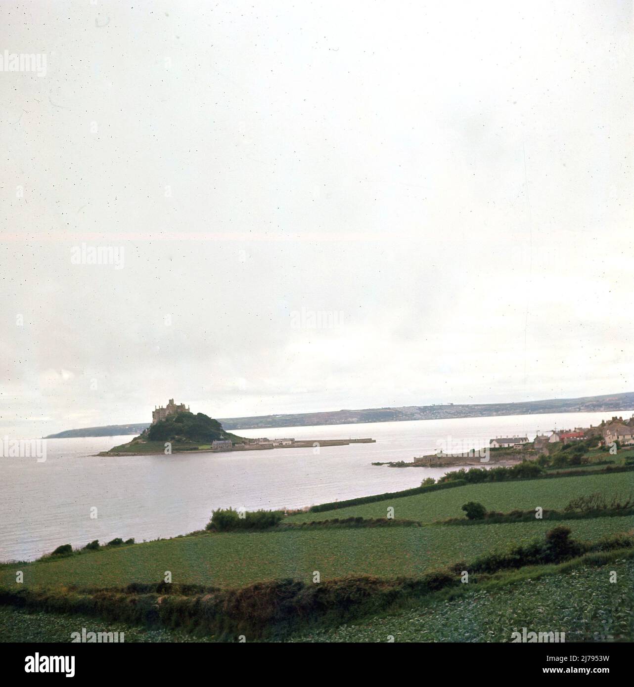 1970, historisch, Saint Micheal's Mount, Mounts Bay, eine historische Burg und Gezeiteninsel vor der Küste von Marazion, Cornwall, England, Großbritannien. Bei Ebbe bedeutet ein Damm aus Granitfelsen, dass die Insel mit dem Festland verbunden ist. Stockfoto